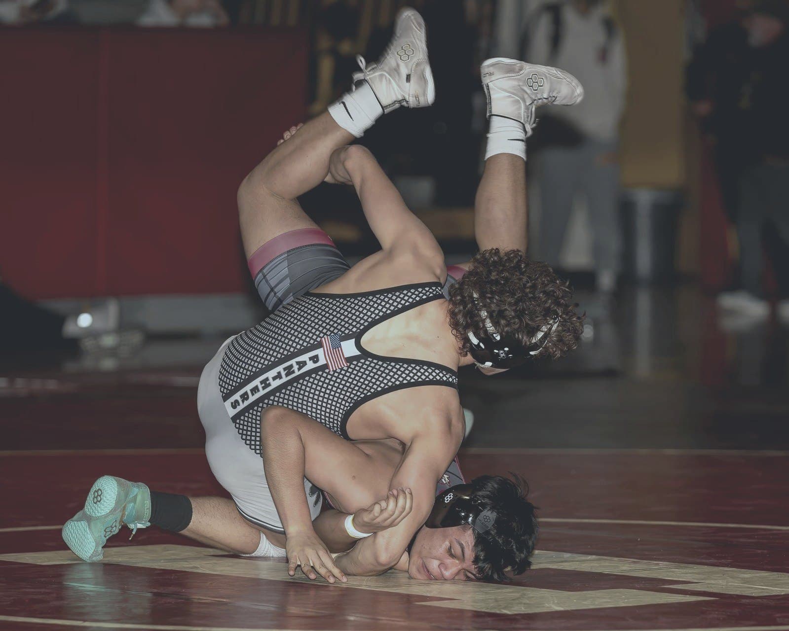 Wrestler attempts pin in dual meet