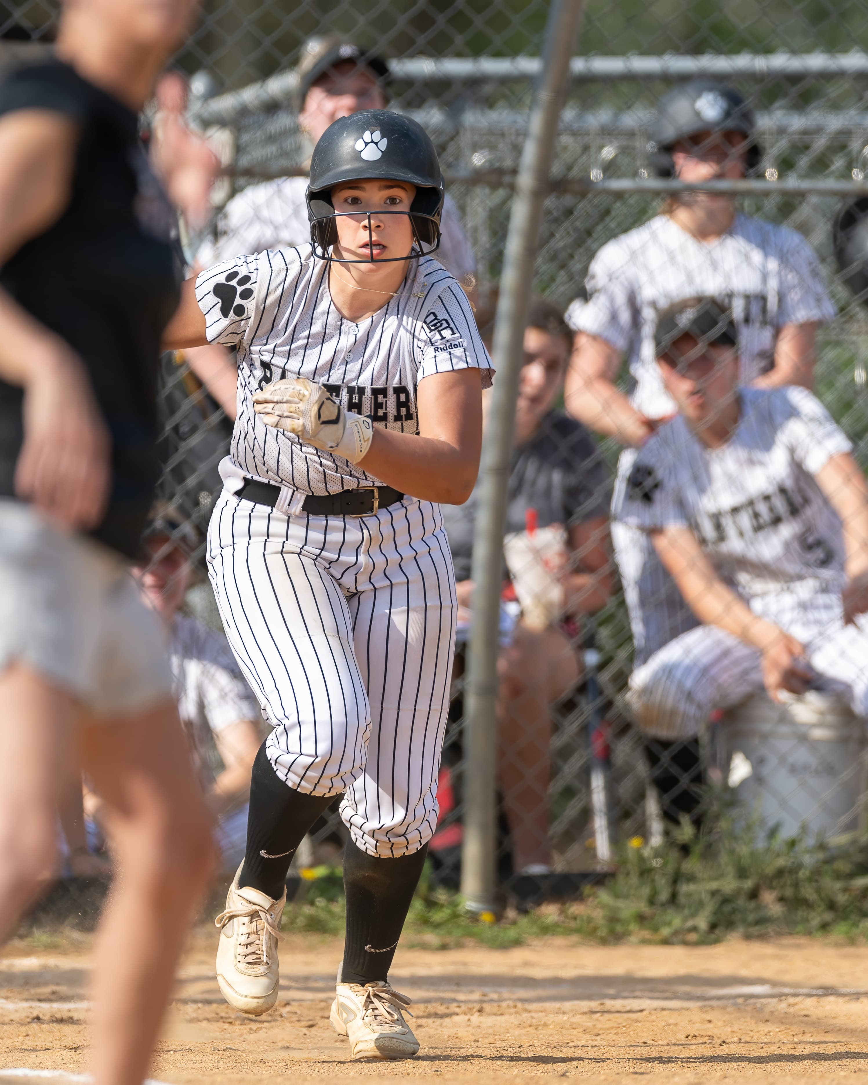 Outfielder tracks a fly ball to the warning track